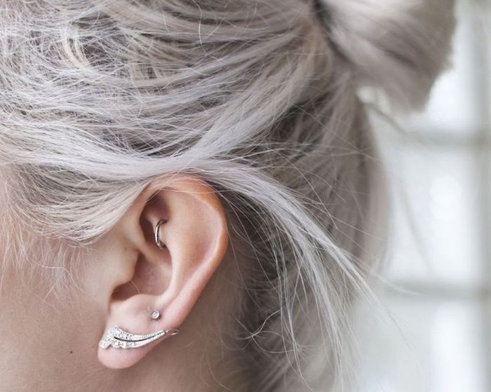 piercing oreille, anneau oreilles en argent, piercing femme, cheveux gris, coiffure chignon haut