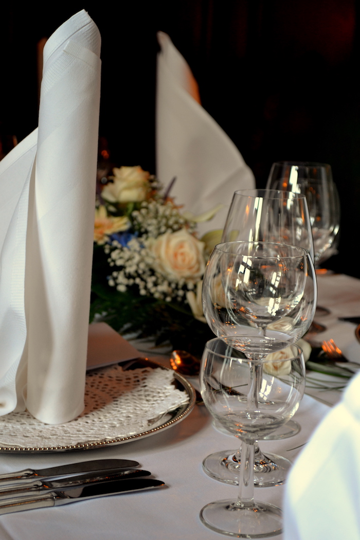 arrangement de table élégant, pliage de serviette blanche en forme de bougie, nappe de table blanche