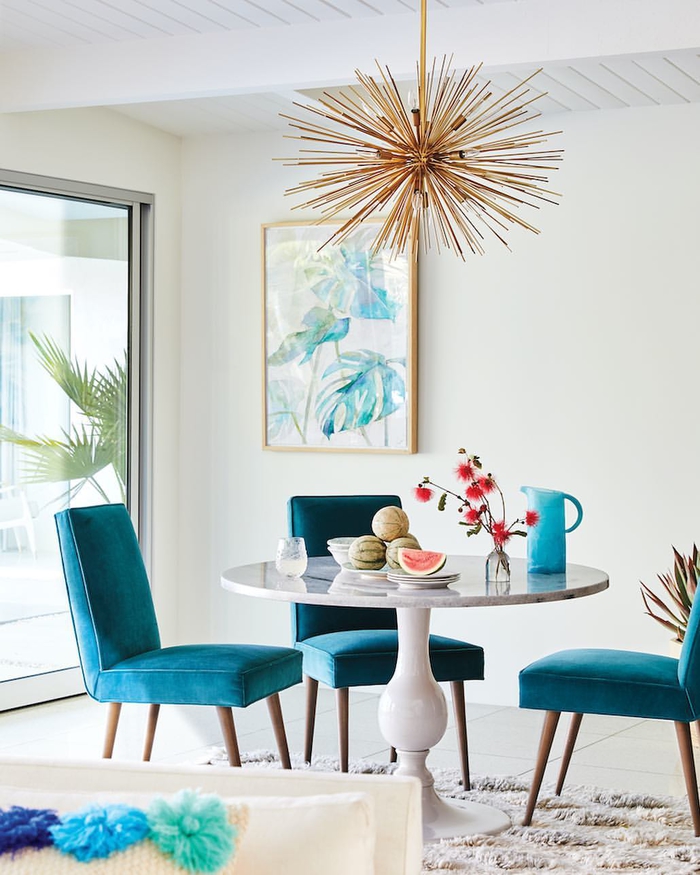 salon blanc moderne illuminé par la couleur bleu sarcelle sur les chaises 