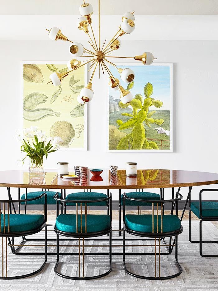une salle à manger colorée de style rétro chic avec une grande table ovale à finition laquée et des chaises bleu paon