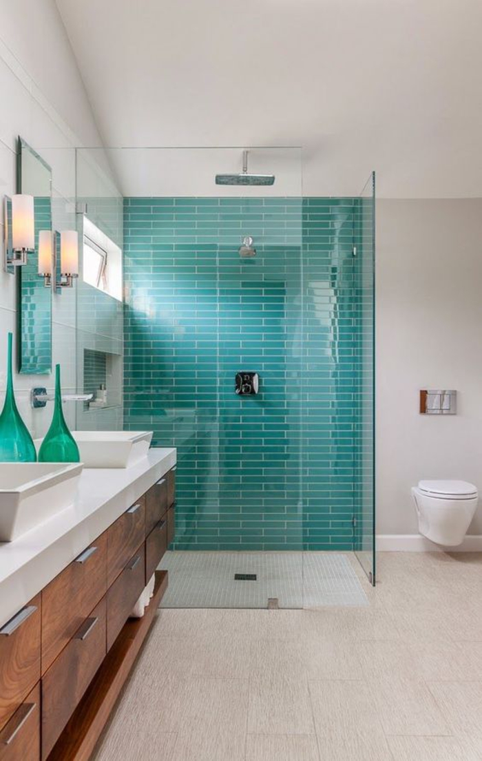 une salle de bain au design contemporain et aux lignes épurées, cabine de douche délimitée par un carrelage vert canard
