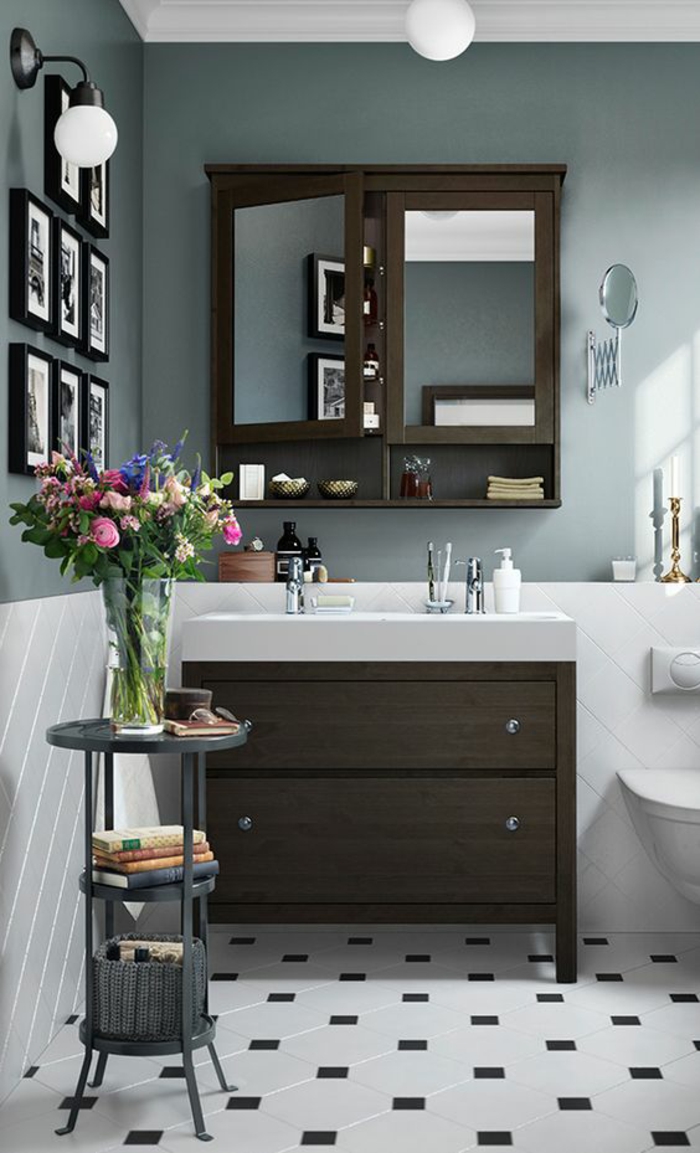 petites salle de bain avec meubles en couleur taupe et des tableaux miniatures aux cadres noirs