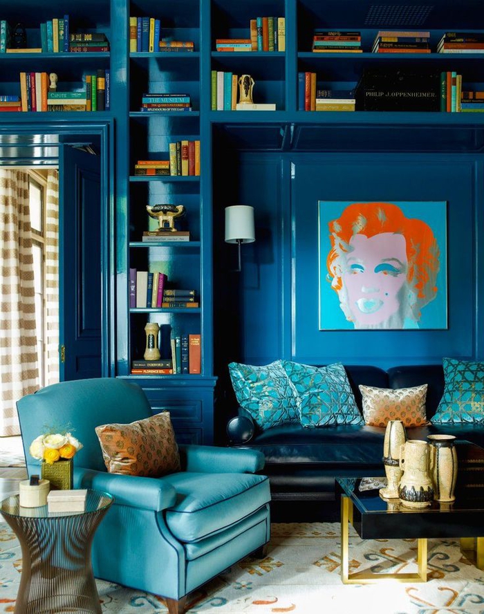 salon éclectique aux nuances de bleu sarcelle et bleu pétrole, une jolie bibliothèque encastrée bleu paon brillant
