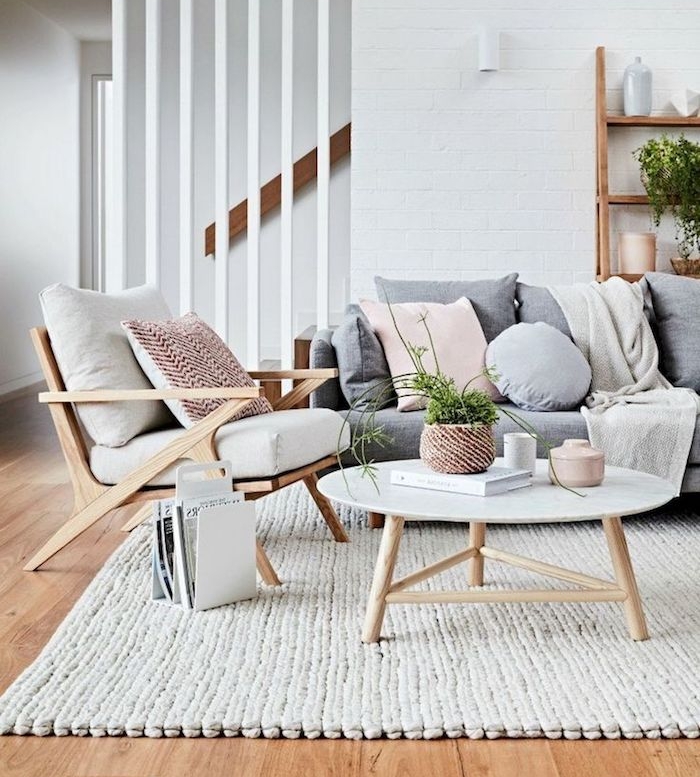 deco scandinave salon, canapé gris avec coussins décoratifs, chaise en bois avec housses blanches, murs blancs