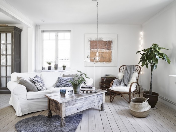 salon mur blanc, tapis en faux fur gris, panier en fibres végétales, plante, coussins décoratifs en gris