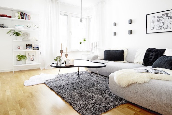 tapis scandinave, étagères en bois peintes en blanc, table asymétrique noire, coussins noirs