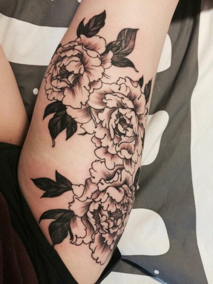 tatouage abstrait, pivoines fleuries sur la jambe avec de l'encre noire, tatouage cuisse femme