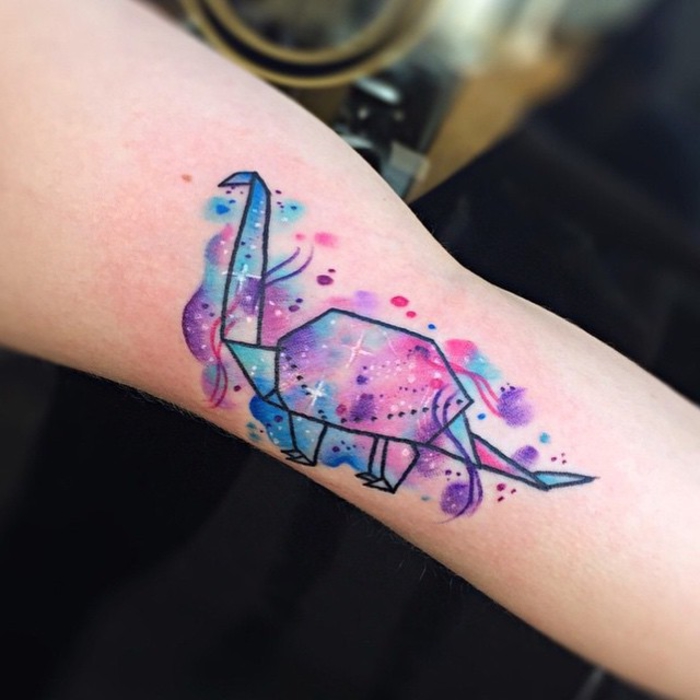 jolie idée d'un tatouage femme bras à motif dinosaure coloré à l'aquarelle