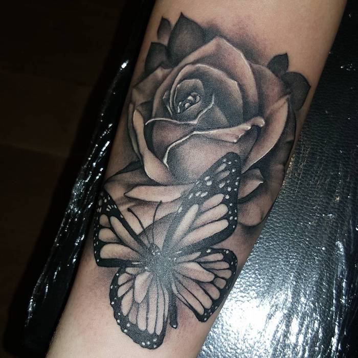  tatouage main homme, dessin sur la peau avec papillon noir et grande rose