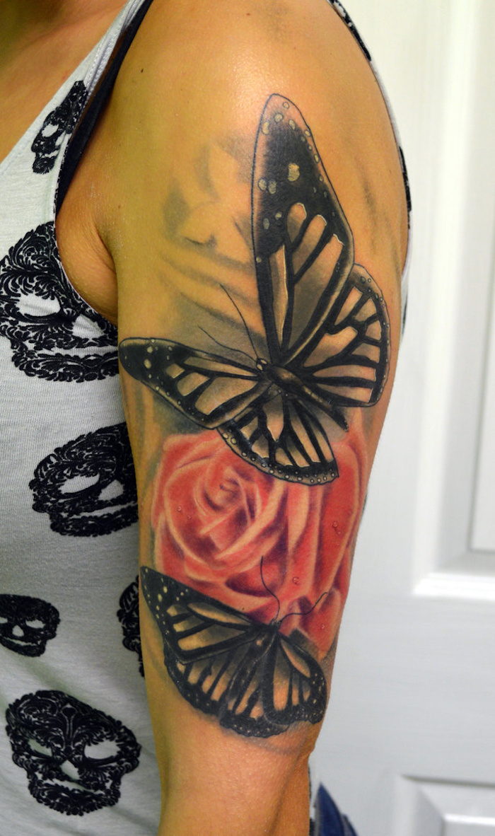 tatouage épaule femme, débardeur gris à crânes noirs, tatouage en rose et papillons noirs