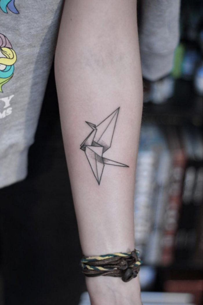 un tatouage avant bras femme minimaliste inspiré des formes géométriques de la grue en origami