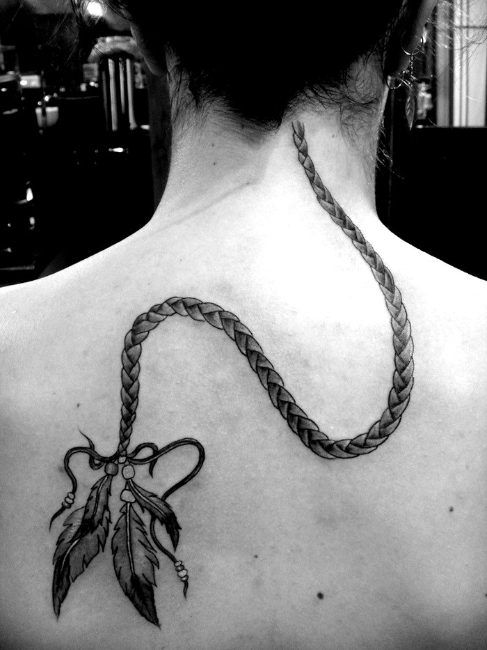 plume tatouage, cheveux attachés en chignon, piercing d'oreilles avec anneau, tatouage natte et plume