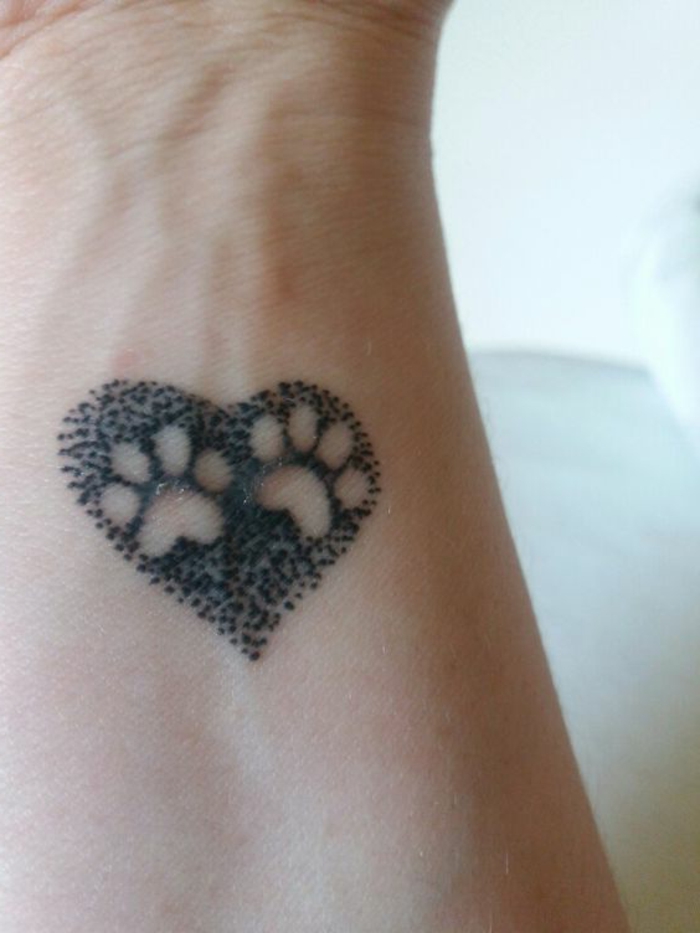 tatouage femme chat, coeur noir avec deux empreintes de pattes dedans