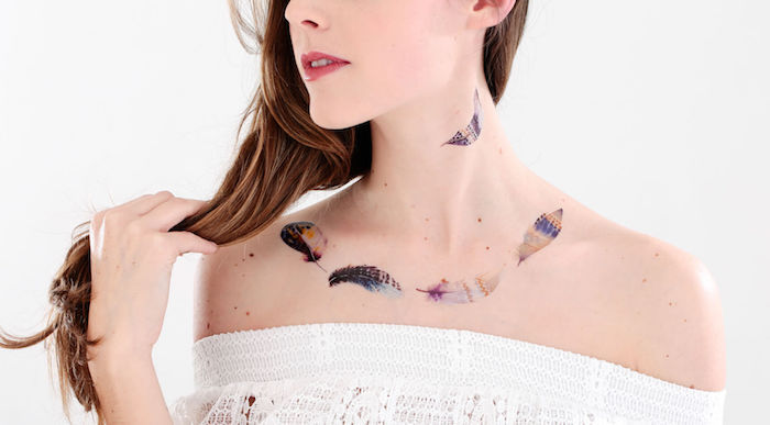 idée tatouage femme, blouse blanche avec manches tombantes pour femme, tatouage en couleurs à motifs plumes