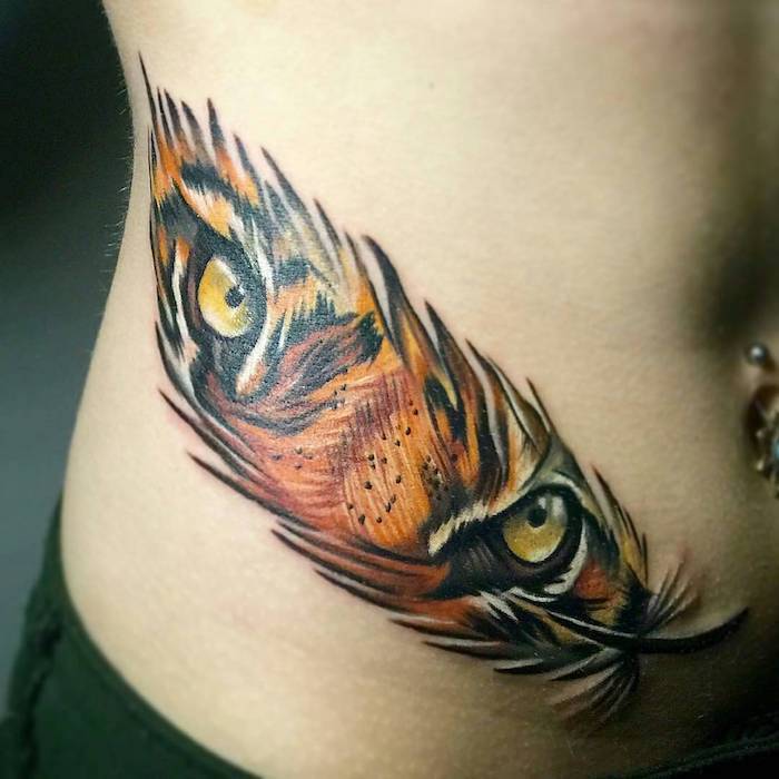 idée tatouage femme, dessin sur la peau à design plume et yeux de tigre, tatouage en couleurs