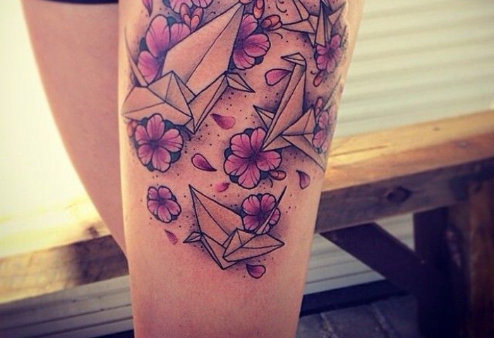 un tatouage géométrique représentant un grand dessin graphique et réaliste combinant le motif origami et floral