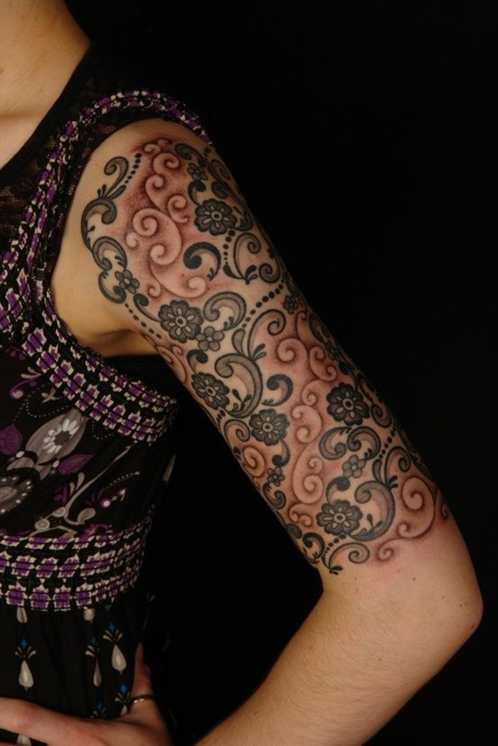 tatouage manchette femme, bras tatoué, fleurs en style abstrait, arabesques colorées