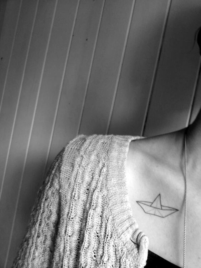 un tatouage minimaliste inspirée des formes origami, dessin discret à la clavicule d'un petit bateau en papier
