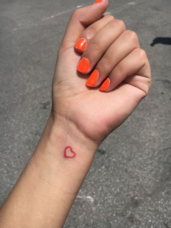 tatouage mini coeur rouge au poignet femme 