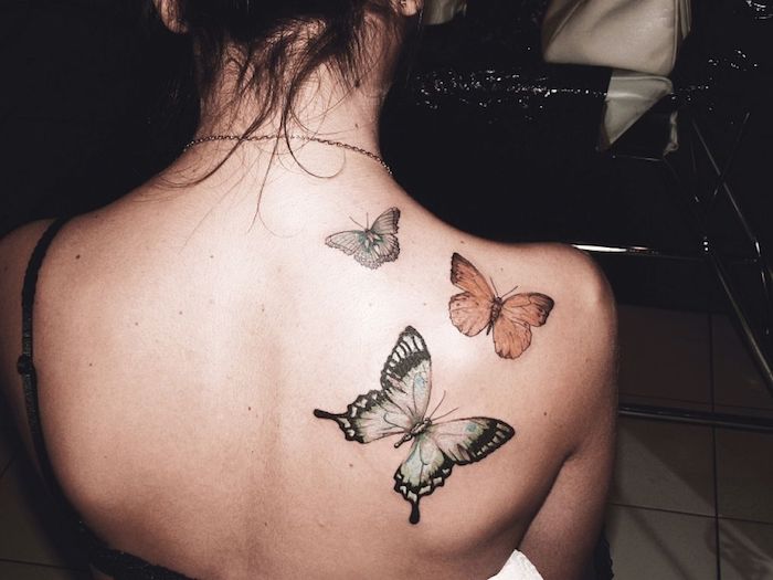 tatouage épaule femme, petits papillons en couleurs, femme aux cheveux attachés