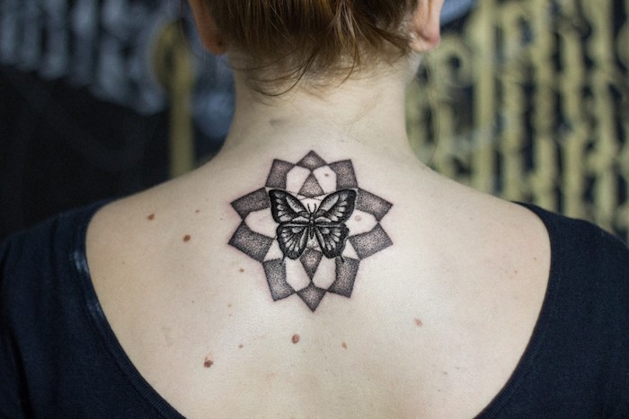 femme tatoué, dessin en encre sur la peau à motif papillon, tatouage design mandala papillon
