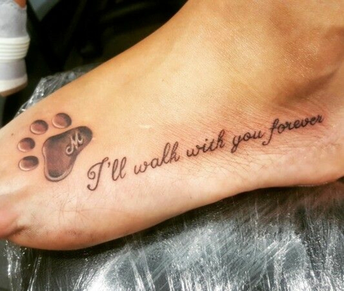 tatouage patte de chien avec initiale, script tatoué au pied