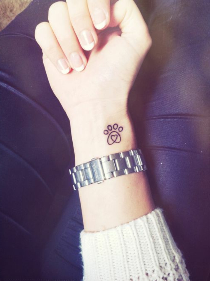 tatouage simple au poignet, patte de chat noire avec un petit coeur