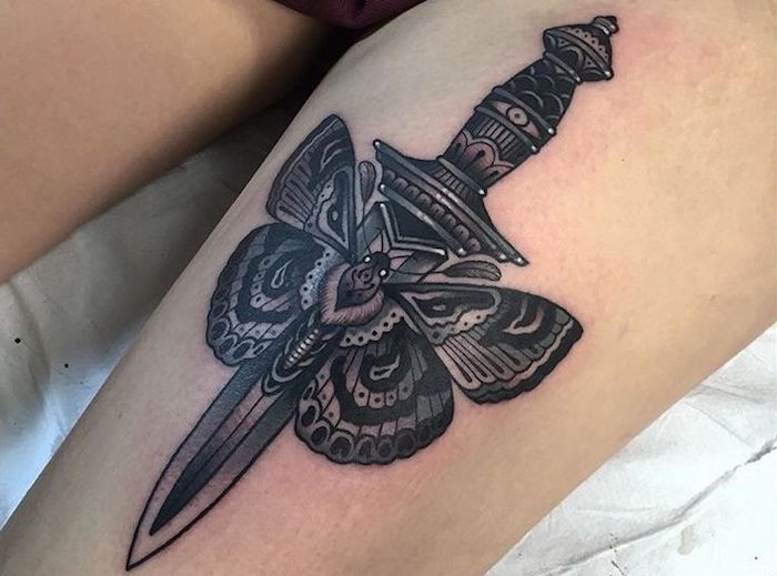 femme tatoué, design femme guerrière, tatouage papillon et épée sur la jambe