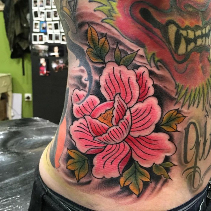 tattoo signification, tatouage fleurs sur la torse, pivoines roses fleuries et lion féroce