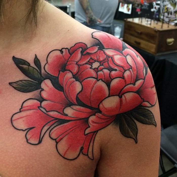 tattoo signification, tatouage fleuri en couleur rouge sur l'épaule, fleur symbole de la bravoure