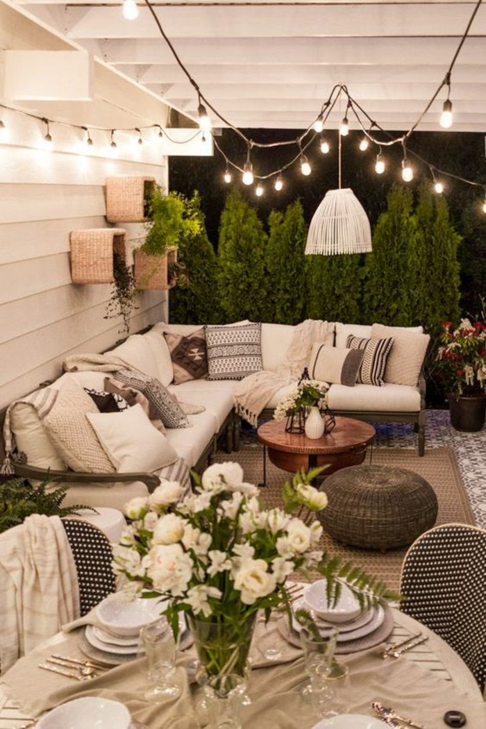 terrasse fermee avec meuble de jardin canapé angulaire et beaucoup de coussins