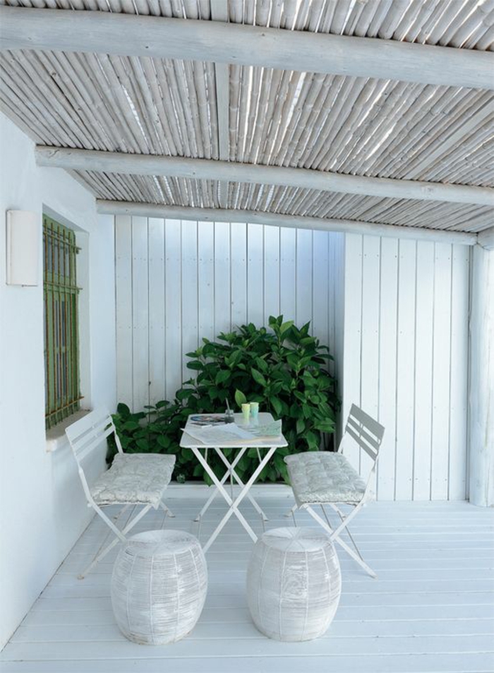 terrasse couverte avec des meubles blancs et le plafond incliné
