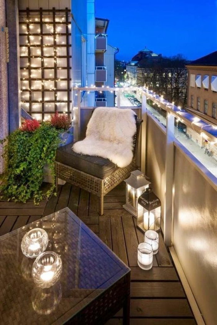 terrasse abritée balcon illuminé avec des ampoules blanches et un revetement du sol en bois synthétique
