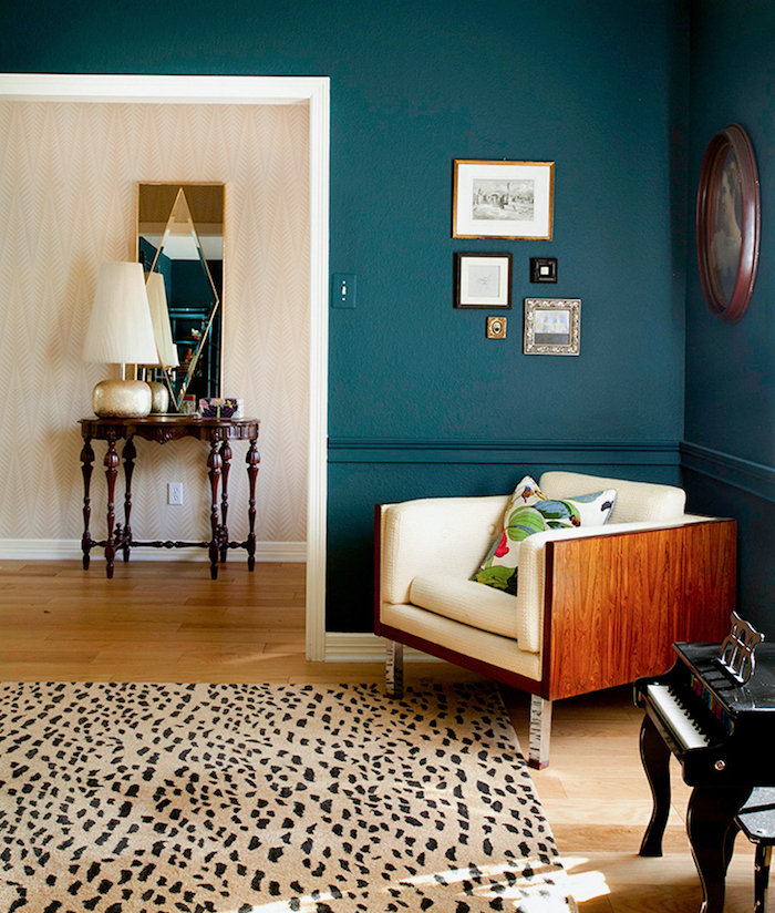 deco moderne, mur peint en bleu foncé, lampe de chevet en beige et cuivre, miroir rectangulaire à motifs géometriques
