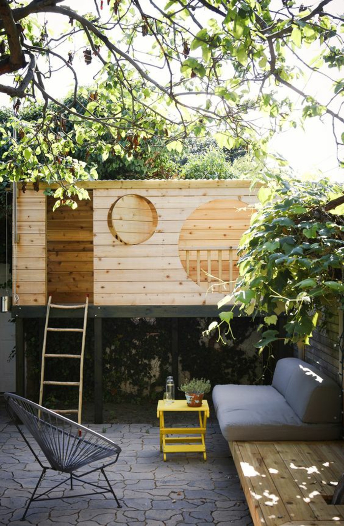aménager un petit jardin avec un coin pour les espaces jeux des enfants avec petite maison et des fenetres rondes en bois clair