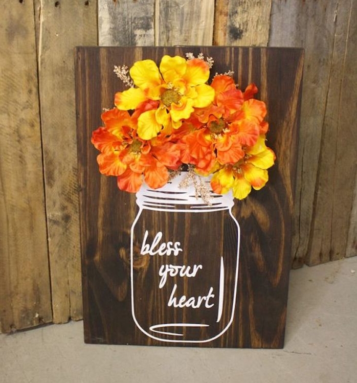 une planche en bois marron avec dessin pot, vase au feutre blanc et bouquet de fleurs jaune et orange, deco automne a faire soi meme