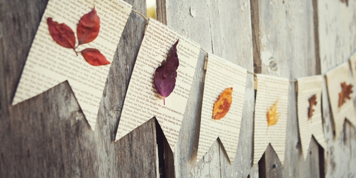 guirlande a fanions avec des bouts de papier livre avec des feuilles mortes collées dessus, activité manuelle automne facile adultes