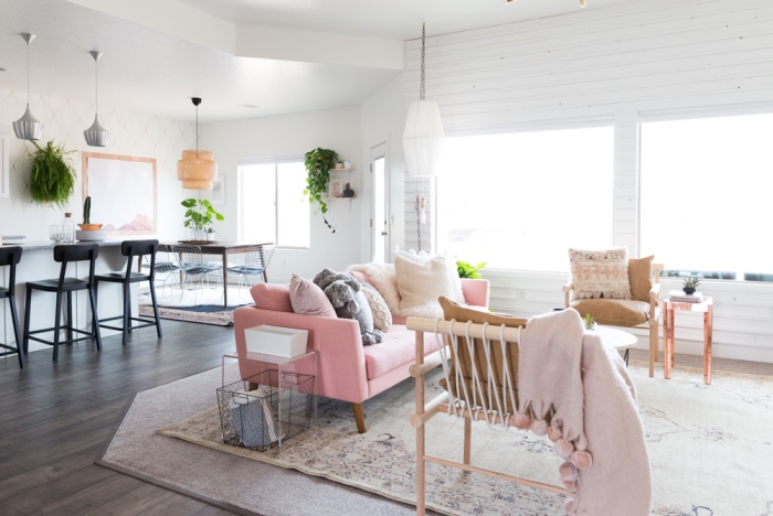 cuisine ouverte sur salon avec idee deco cocooning, tapis oriental usé, canapé rose, chaises en bois, lambris blanc, suspensions originales