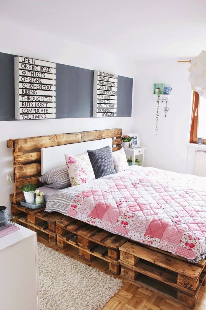une chambre à coucher girly très accueillante avec lit en palette europe et une déco murale originale en panneau d'affichage à lettes