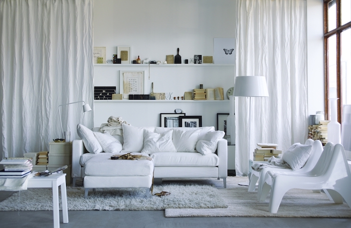 deco salon scandinave avec tapis cocooning de fausse fourrure, canapé, table et chaises blancs, étagères murales blanches avec déco vintage