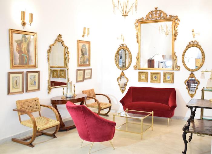 salon baroque avec fauteuil et canapé rouge, miroirs et cadres dorés, mobilier vintage en bois, deco luxueuse