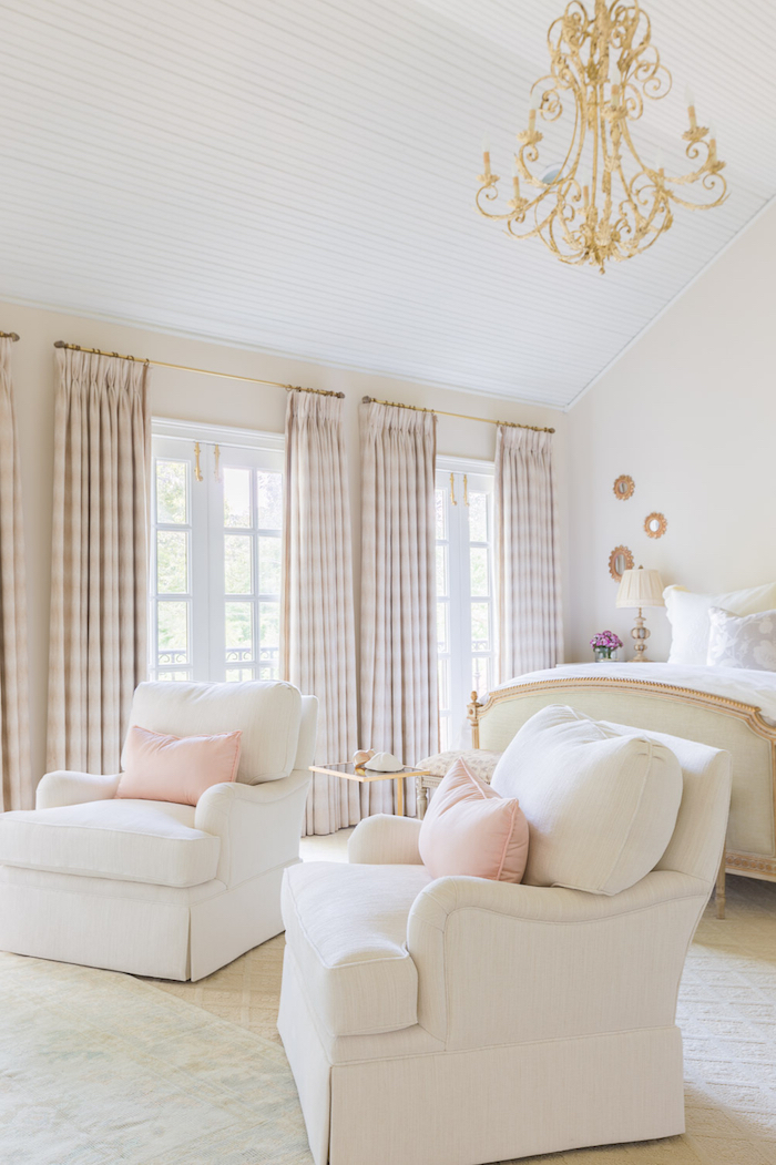 intérieur rose et blanc, plafond en bois peint en blanc, kingsize lit au cadre beige et or, lampe de chevet beige