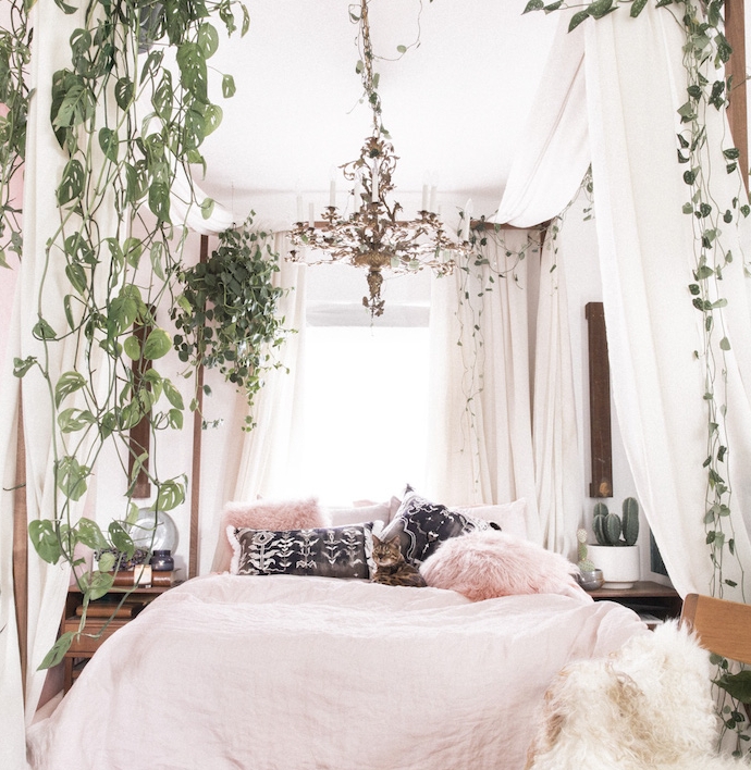 chambre adulte cocooning, linge de lit rose, coussins blanc, noir et rose, lit baldaquin et plantes grimpantes, lustre élégant