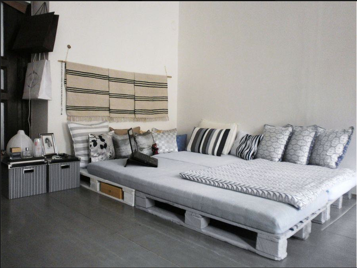 une chambre à coucher en gris et blanc de style ethnique chic avec un sommier en palette 