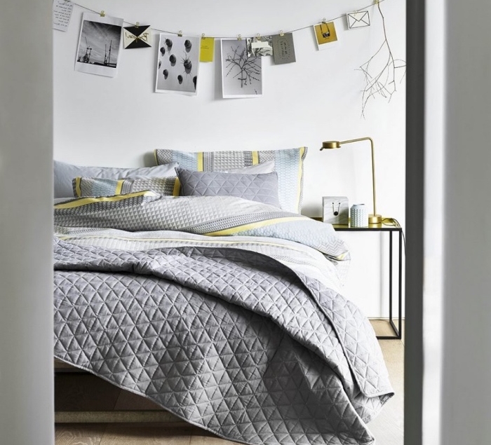 idée comment décorer une chambre scandinave, linge de lit gris aux accents jaunes, parquet clair, table de nuit metal, guirlande de photos