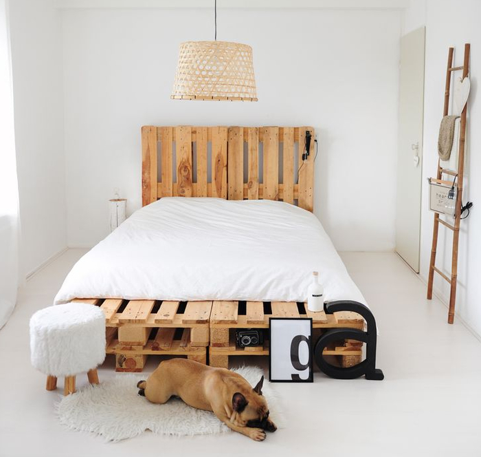 chambre à coucher minimaliste avec un lit et une tete de lit en palette comme accents forts 