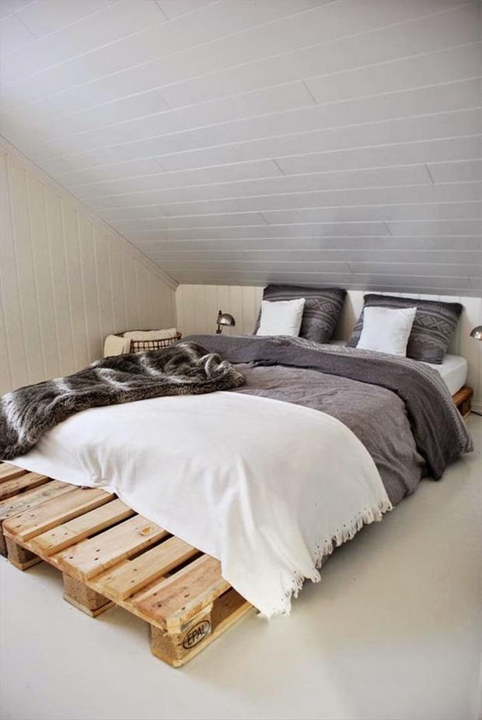 aménagement pratique et fonctionnel d'une chambre à coucher sous pente, lit en palette minimaliste posé à ras du sol