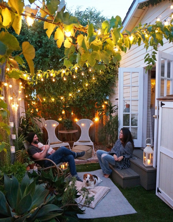 aménager un petit jardin avec des chaises blanches des bougies t des girlandes d ampoules lumineuses
