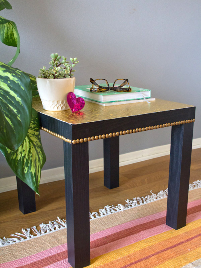 idée originale pour relooker un meuble ikea sans peinture, petite table basse unie noire transformée avec du papier peint et des clous de tapissier 