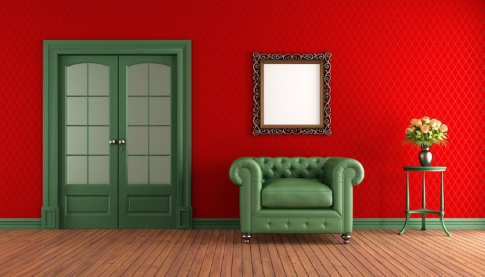 rouge couleur complémentaire vert, canapé et porte verte, revêtement mur rouge, miroir vintage, parquet en bois clair